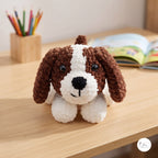 A crocheted dog toy with brown and white yarn sits on a light wooden desk, with a pencil holder and an open book blurred in the background.