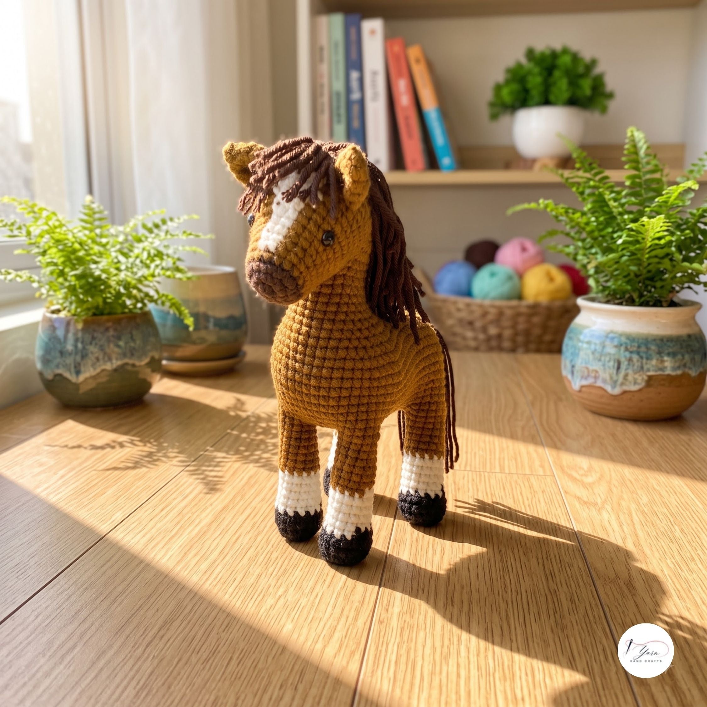A crocheted horse toy standing on a wooden floor in a sunlit room, with potted ferns, books, and a basket of yarn in the background.
