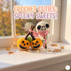Two crocheted Halloween-themed plush toys displayed on a windowsill: two orange pumpkin cuties with black jack-o'-lantern faces and green tops, and a white crocheted ghost character wearing a pink scarf. The scene is lit by warm window light with decorative autumn leaves and fairy lights, and the text 'CROCHET CUTIES: SPOOKY SWEETS!' appears at the top.