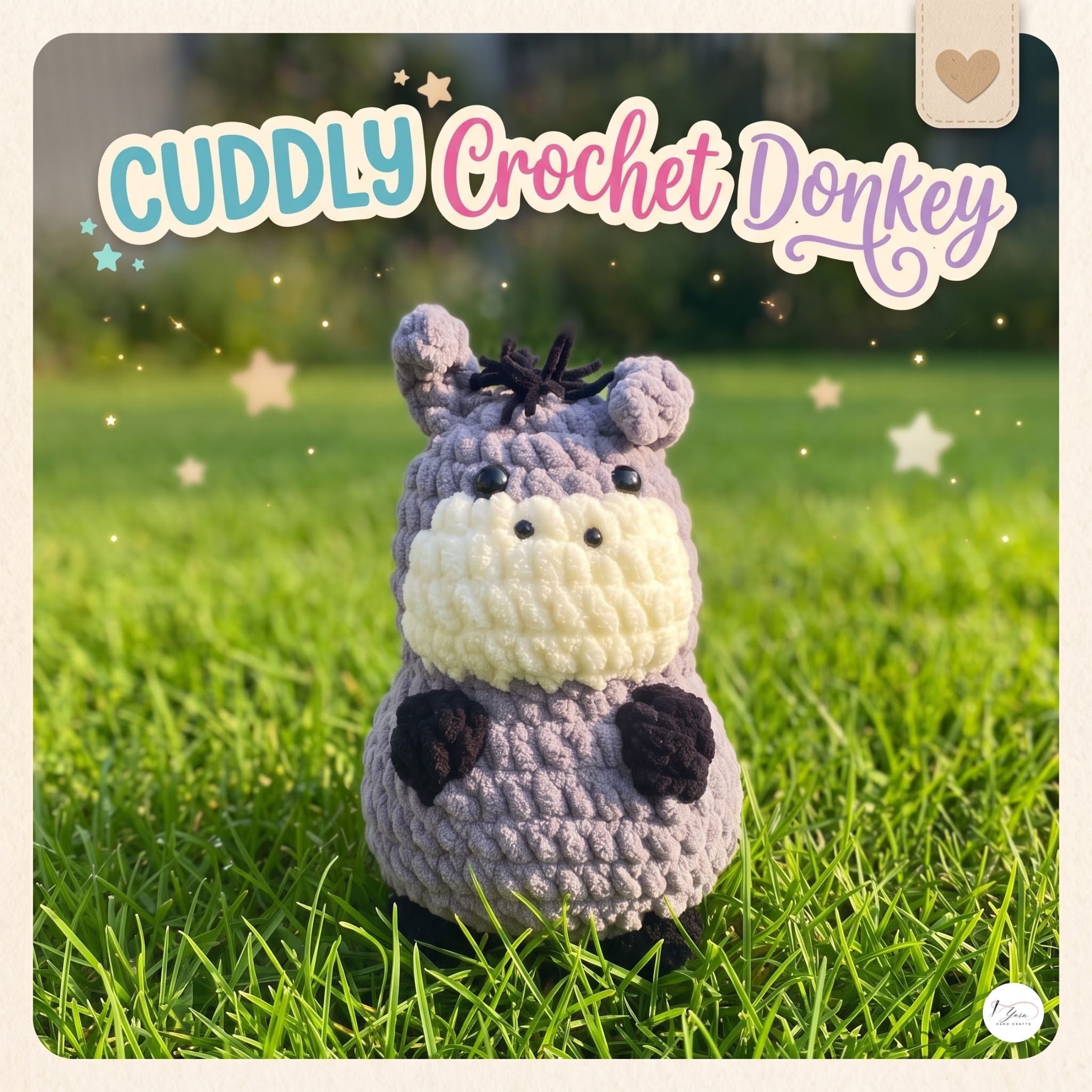 A crocheted plush donkey toy labeled 'CUDDLY Crochet Donkey' stands on green grass outdoors. The donkey is lavender-gray with a cream face and neck, black nose and hooves, and small dark ears.