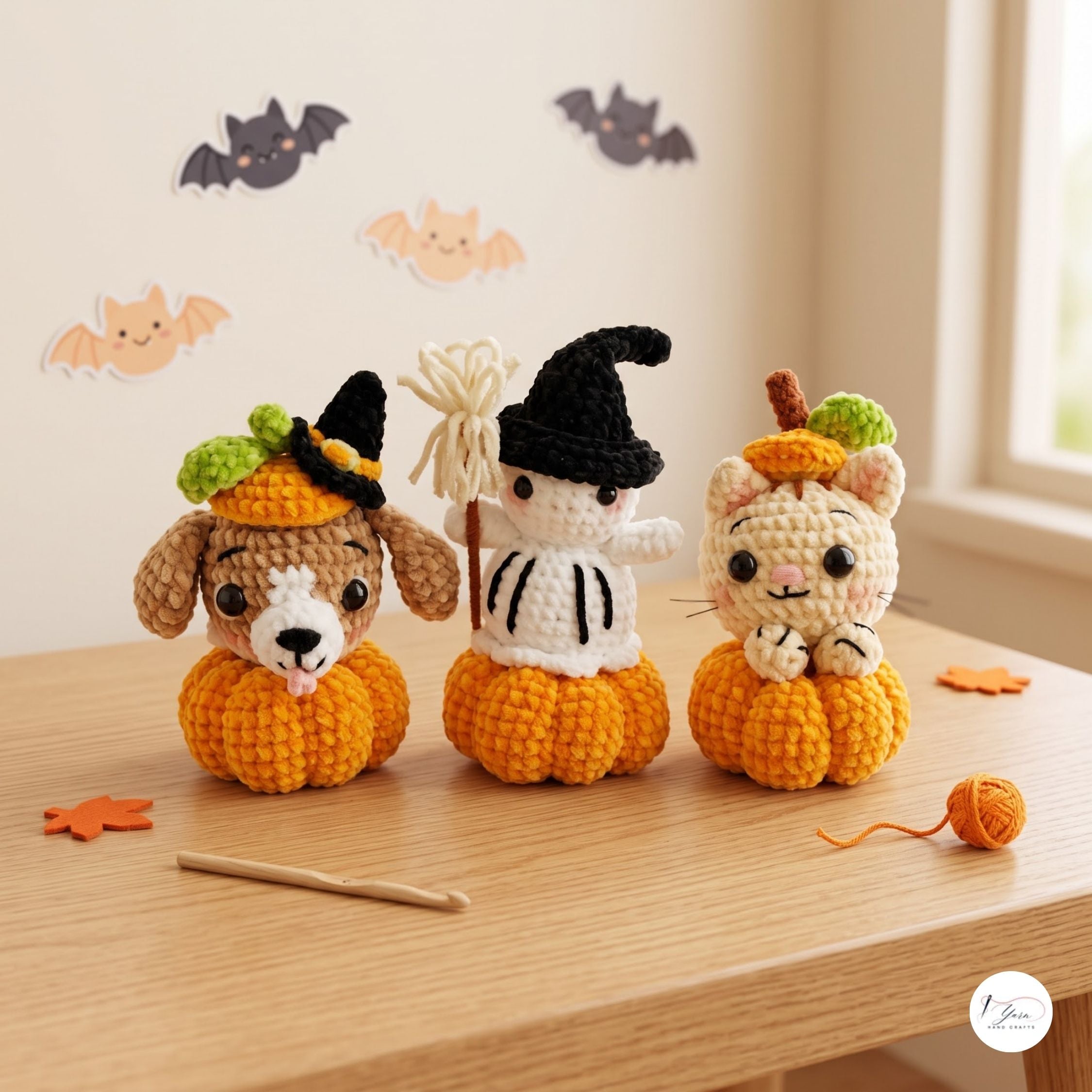 Three cute crocheted Halloween characters sitting on orange pumpkins, displayed on a wooden table with bat decorations in the background.