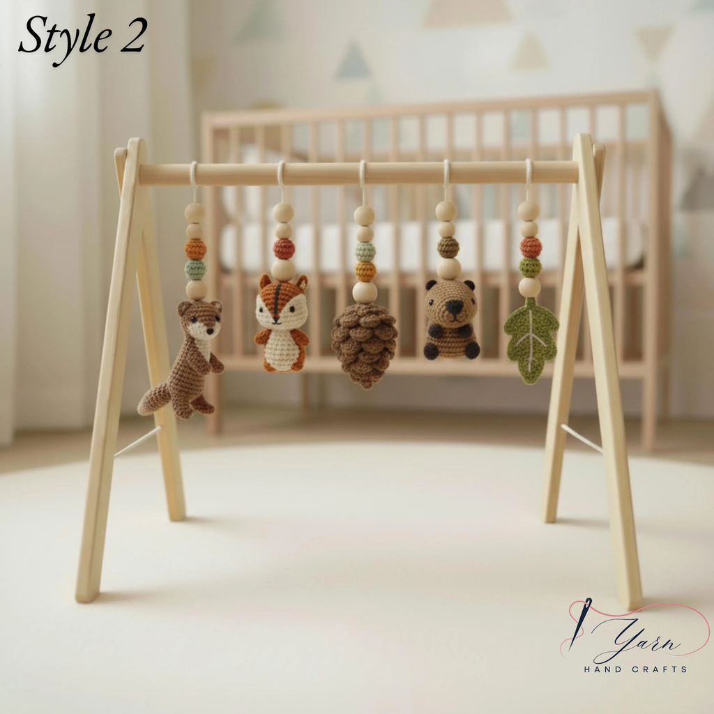 A wooden baby mobile stand with five crocheted animal and nature hanging toys, shown in a softly lit nursery setting with a crib in the background. The text 'Style 2' appears in the top left, and a 'Yarn Hand Crafts' logo is in the bottom right.