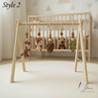 A wooden baby mobile stand with five crocheted animal and nature hanging toys, shown in a softly lit nursery setting with a crib in the background. The text 'Style 2' appears in the top left, and a 'Yarn Hand Crafts' logo is in the bottom right.