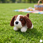 A crocheted dog toy with brown and white yarn sits on a green grass lawn, with a blurred picnic blanket and basket in the background.