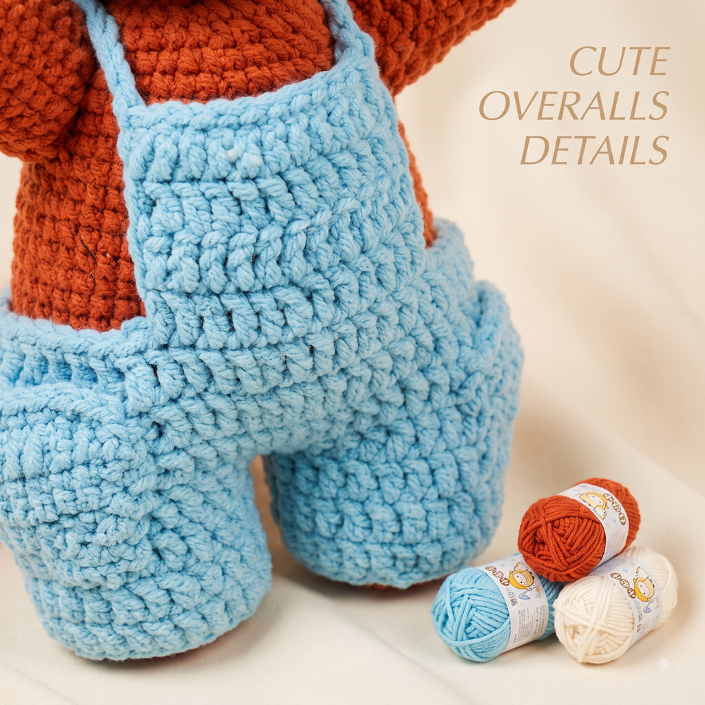 A crocheted plush toy or doll wearing light blue overalls and an rust-orange top, shown on a soft cream background with three balls of yarn and the text 'CUTE OVERALLS DETAILS'.