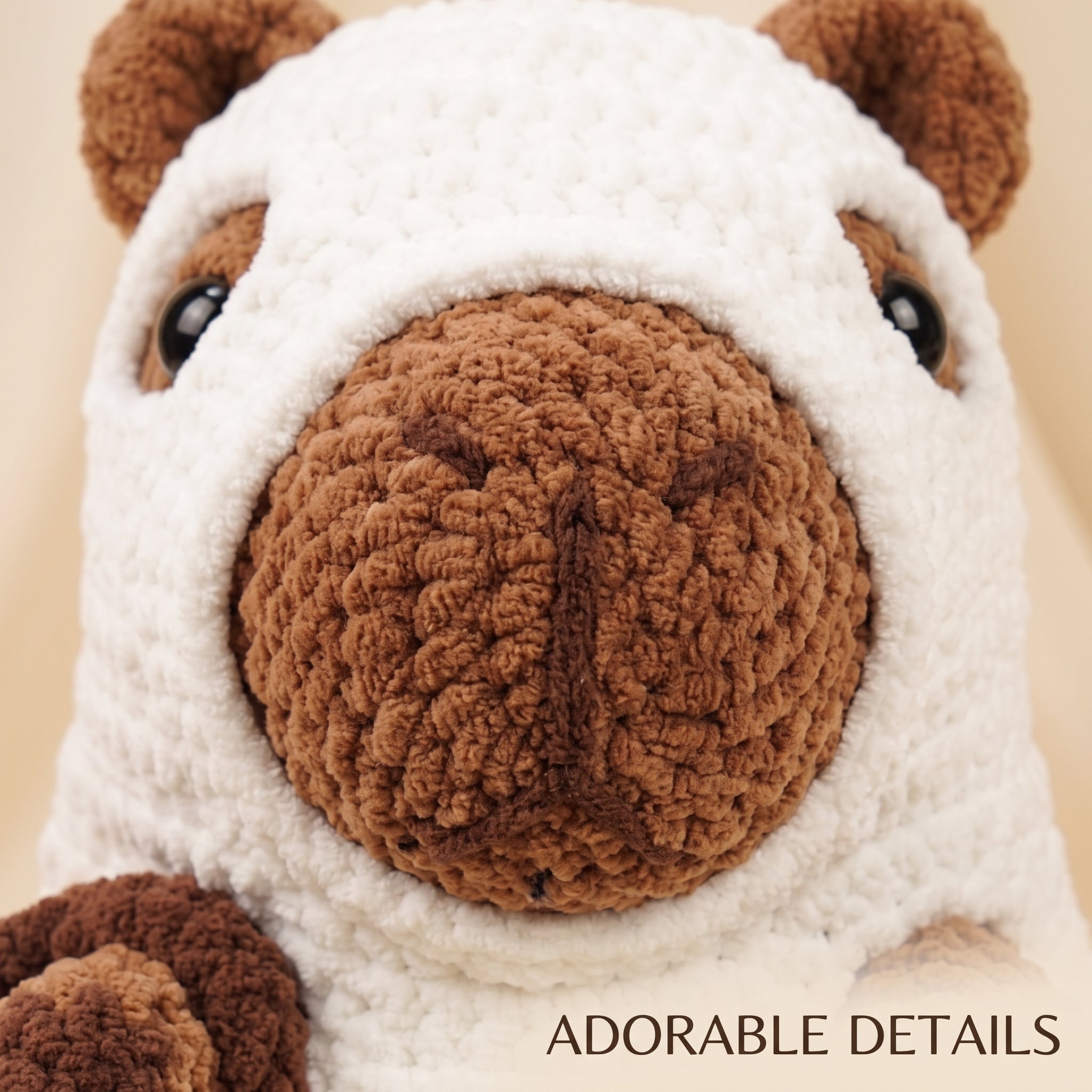 Close-up of a crocheted plush toy face with a white body, brown ears and snout, black bead eyes, and the text 'ADORABLE DETAILS' at the bottom right.