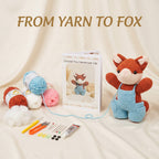 A crocheted fox toy wearing light blue overalls is displayed on a cream fabric backdrop with yarn balls, crochet tools, stuffing, and a booklet titled 'Crochet Fox Handmade Gift.' Large text at the top reads 'FROM YARN TO FOX.