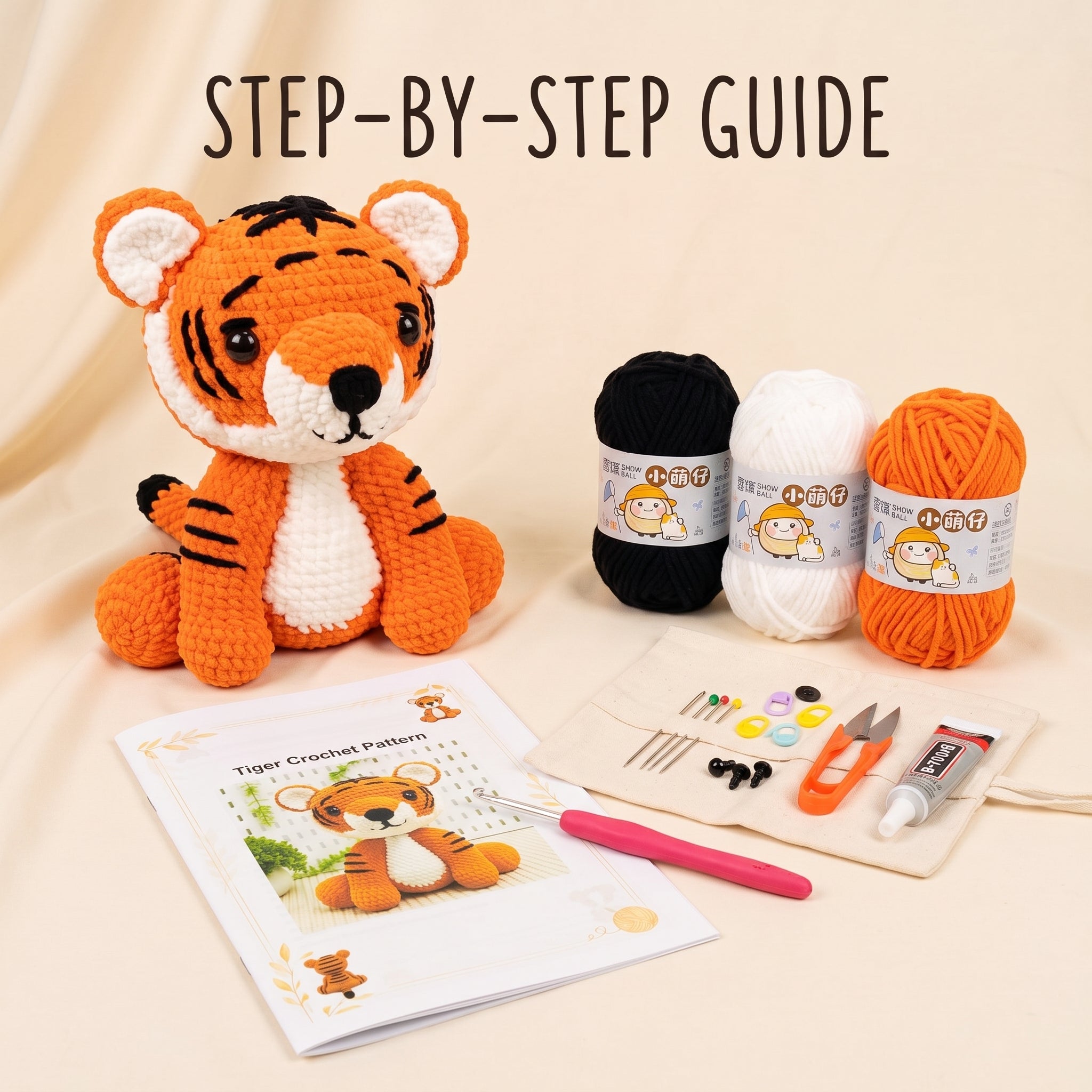 A crocheted tiger plush toy sits beside a printed 'Tiger Crochet Pattern' booklet, a pink crochet hook, and a small kit pouch with scissors, buttons, thread, and yarn balls on a warm beige background. Large text at the top reads 'STEP-BY-STEP GUIDE'.