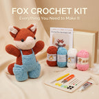 A crocheted fox toy in brown and light blue overalls is displayed with a crochet kit set including four balls of yarn in brown, blue, white, and pink, a crochet hook set in a pouch, and a gift box. The text 'FOX CROCHET KIT' is displayed at the top.