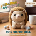 A crocheted hedgehog doll sits on a wooden table in a warm indoor setting, with yarn balls, a mug, and a window in the background. Text overlays read 'HEDGEHOG AMIGURUMI', '6 INCHES / 16cm', and 'CUTE CROCHET DOLL HANDMADE WITH LOVE'.
