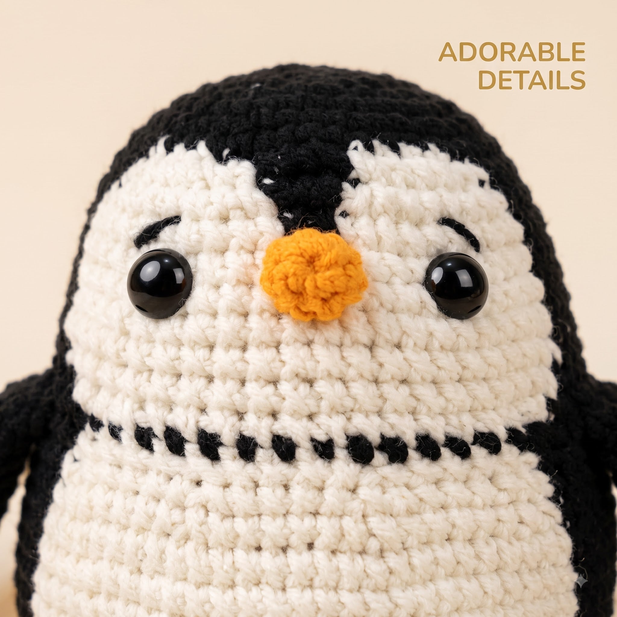 A close-up of a crocheted penguin toy with black and white yarn, a small orange beak, and glossy black eyes, on a warm beige background with the text 'ADORABLE DETAILS' in the top right.