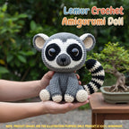 A crocheted amigurumi doll shaped like a lemur/raccoon sits on two human hands, with a blurred garden and bonsai tree in the background. Large text at the top reads 'Lemur Crochet Amigurumi Doll' and a note at the bottom says product images are for illustration purposes only.