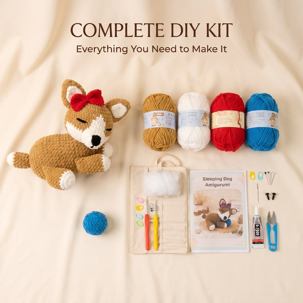 A complete DIY amigurumi kit laid out on a beige fabric background, featuring a crocheted sleeping dog with a red bow, four balls of yarn in tan, cream, red, and blue, a tool pouch with crochet hooks and thread, a booklet labeled 'Sleeping Dog Amigurumi,' a small blue ball, and sewing scissors.