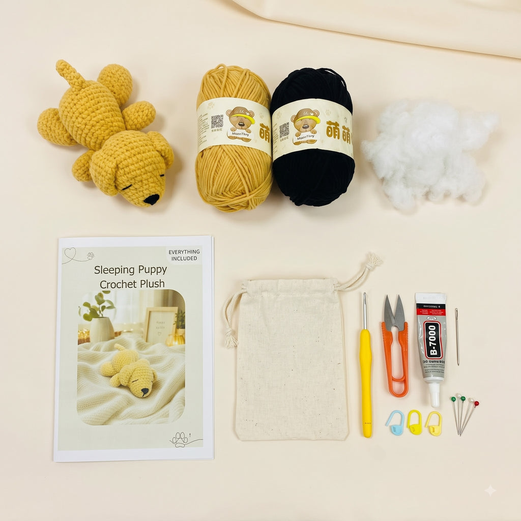 Crochet puppy kit laid out on a light beige background, including a finished yellow crochet puppy plush, a black yarn ball, white stuffing, a printed instruction booklet, a cream drawstring bag, a yellow crochet hook, orange-handled scissors, a tube of PTFE glue, and small sewing needles and stitch markers.