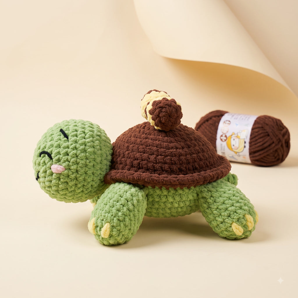 A crocheted turtle plush toy in light green and dark brown, shown alongside a ball of matching brown yarn on a warm beige background.