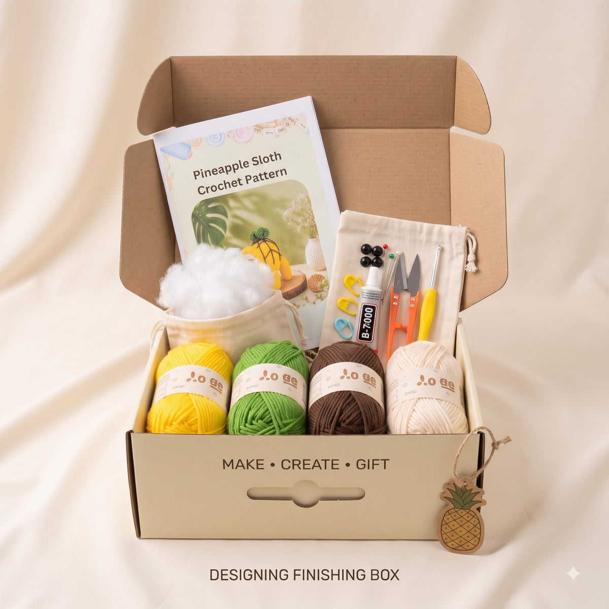 An open kraft cardboard gift box filled with crochet kit contents, including a crochet pattern booklet, cotton ball, yarn balls in yellow, green, brown, and cream, a small pouch, and tools. The box is photographed on a soft beige fabric background with the text 'DESIGNING FINISHING BOX' below.