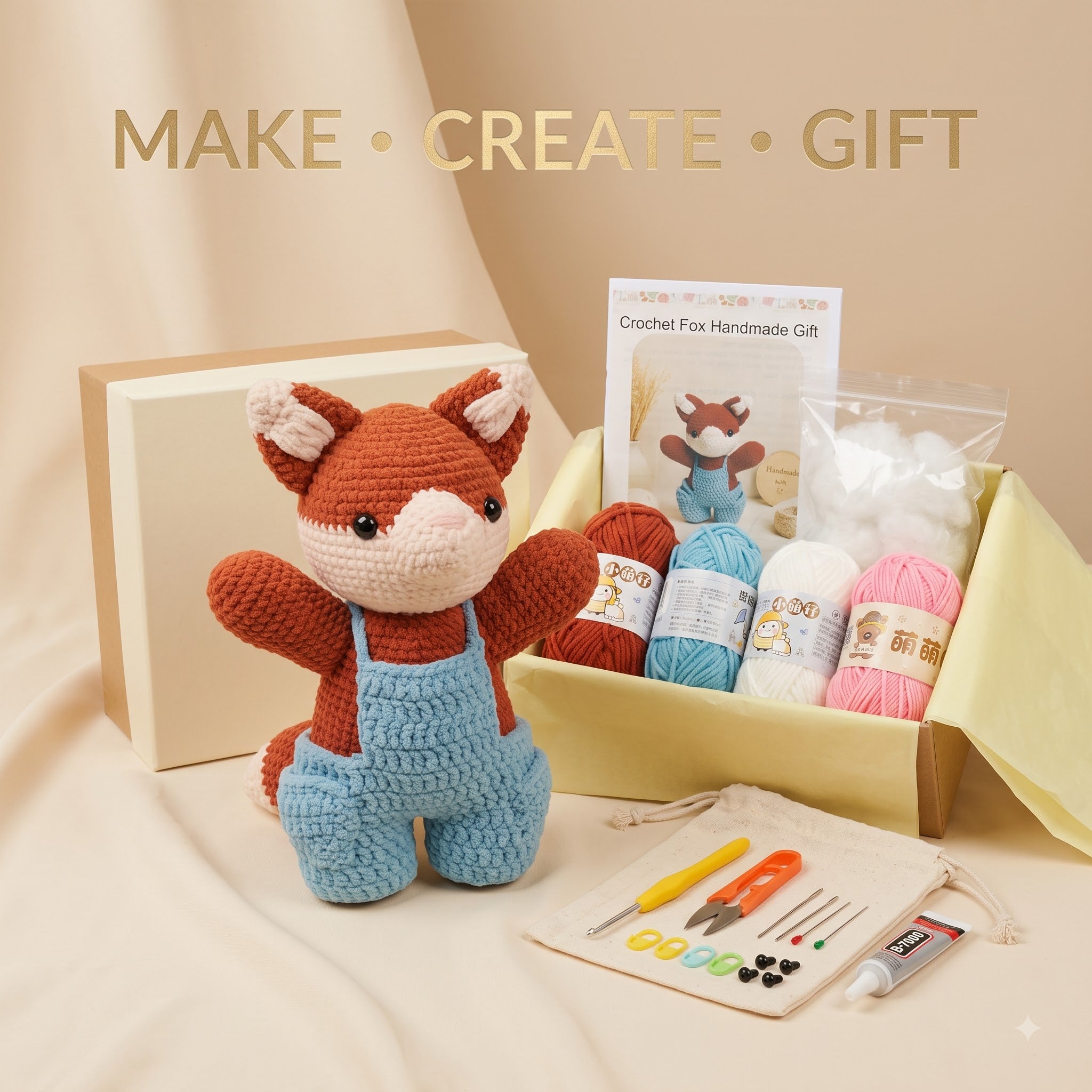 Crochet fox handmade gift kit displayed on a beige fabric surface with a cream backdrop. The kit includes a finished crocheted fox doll in brown and blue, a gift box, a booklet, yarn balls in brown, blue, white, and pink, a small tool pouch, and crafting tools.