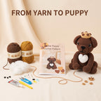 Crochet pattern kit for making a puppy, featuring a finished brown crocheted puppy with a white heart and gold crown, a book titled 'Cookie Puppy Crochet Pattern', two balls of yarn, crochet tools, stuffing, and small decorative pieces on a beige background with 'FROM YARN TO PUPPY' text at the top.