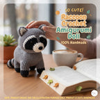 A crocheted raccoon amigurumi doll sits on a wooden table next to an open book, a coffee cup, and a person's hand gently touching its head. Text on the image reads 'So Cute! Raccoon Crochet Amigurumi Doll 100% Handmade'.