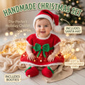 A baby wearing a handmade Christmas outfit set consisting of a red dress with a green bow, matching red booties, and a Santa hat, sitting on a blanket with warm fairy lights. Text overlays describe the set and its contents.
