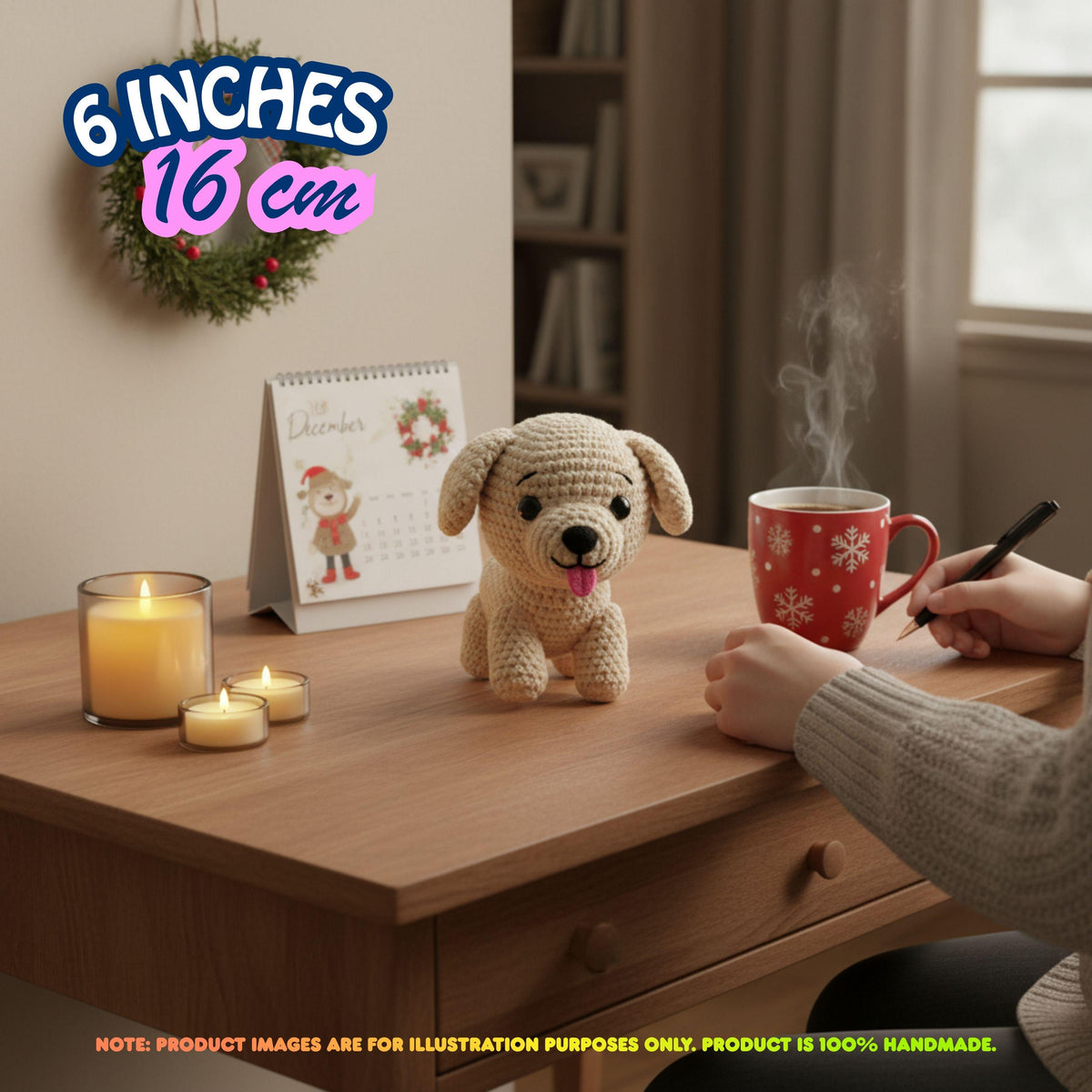 A crocheted beige dog plush toy sits on a wooden desk in a cozy indoor setting, with a person's hands holding a red mug nearby. The scene includes candles, a small calendar, and a wreath on the wall, with text overlays indicating the size as 6 inches / 16 cm.