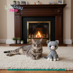 Handmade 6 inches 16cm grey tabby cat crochet amigurumi plush doll sitting next to a real tabby cat in front of a fireplace