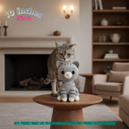 Handmade 10 inches 25cm grey tabby cat crochet amigurumi plush doll sitting next to a real tabby cat in front of a fireplace