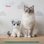 A fluffy white and gray cat sits next to a crocheted plush cat toy on a wooden surface against a light gray cloud-patterned wall. Text in the top left reads '8 inches 20cm', and a teal note at the bottom says product images are for illustration purposes only and the product is 100% handmade.