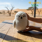 Handmade Snowy Owl crochet amigurumi plush doll held gently by hands on a wooden outdoor surface, with text indicating 12 inches 30 cm size.