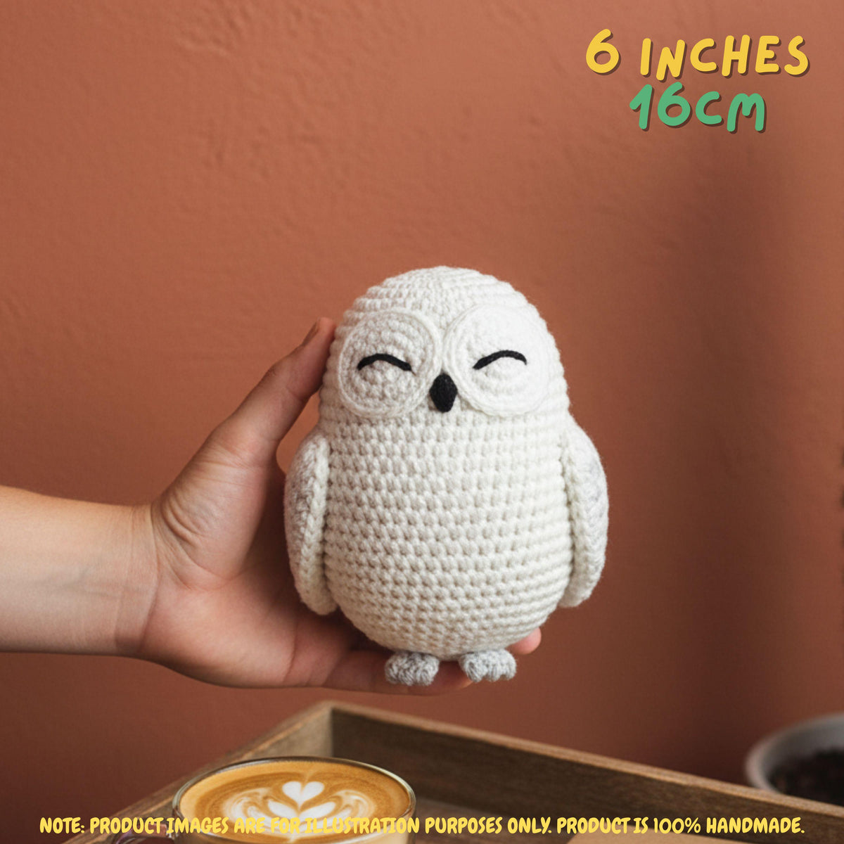 A hand holds a small crocheted owl toy against a warm terracotta wall. The text '6 INCHES 16CM' appears in the top right, and a note at the bottom says the product image is for destination purposes only and the product is 100% handmade.