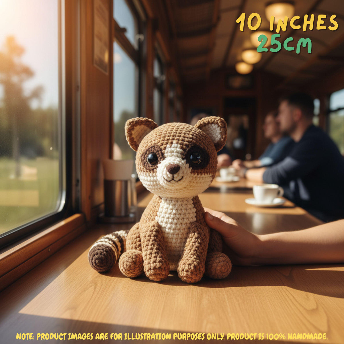 Handmade Ringtail crochet amigurumi plush doll with a striped tail resting on a wooden table held gently by a hand, in a train car setting with text indicating 10 inches 25 cm size.