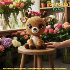 A crocheted plush deer toy sits on a small wooden stool in a flower-filled room. A human hand is touching the toy, and text in the top right says 12 inches / 30 cm, with a note at the bottom stating product images are for illustration purposes only and the product is 100% handmade.