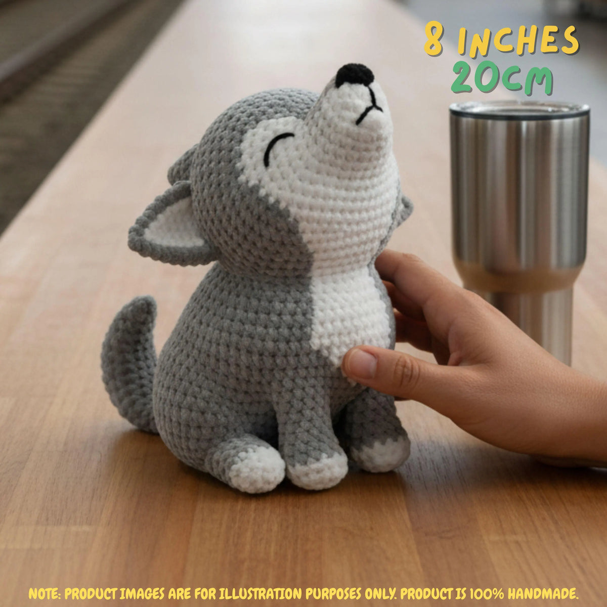 Handmade grey and white crochet wolf amigurumi doll in a howling posture sitting on a table next to a stainless steel tumbler, featuring "8 INCHES / 20CM" text overlay.