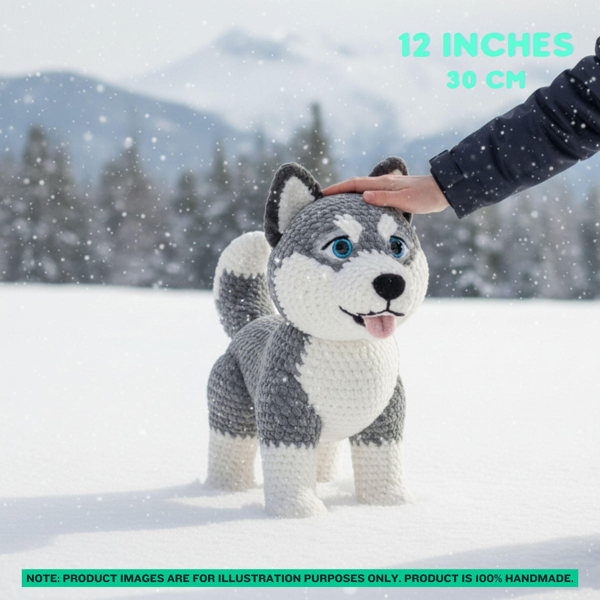 A hand-crocheted husky dog toy standing in the snow, with a human hand gently touching its head. The background shows a snowy outdoor scene with blurred trees and mountains.