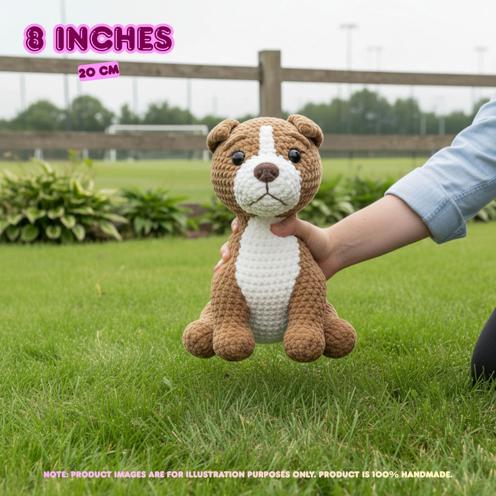A crocheted dog toy held by a person's hand outdoors on a grassy lawn, with text overlays indicating 8 inches (20 cm) size. The toy is brown and white with black eyes and a stitched nose.