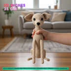 A crocheted dog plush toy held by a human hand in a living room setting, with text overlays indicating its size as 10 inches / 25 cm.
