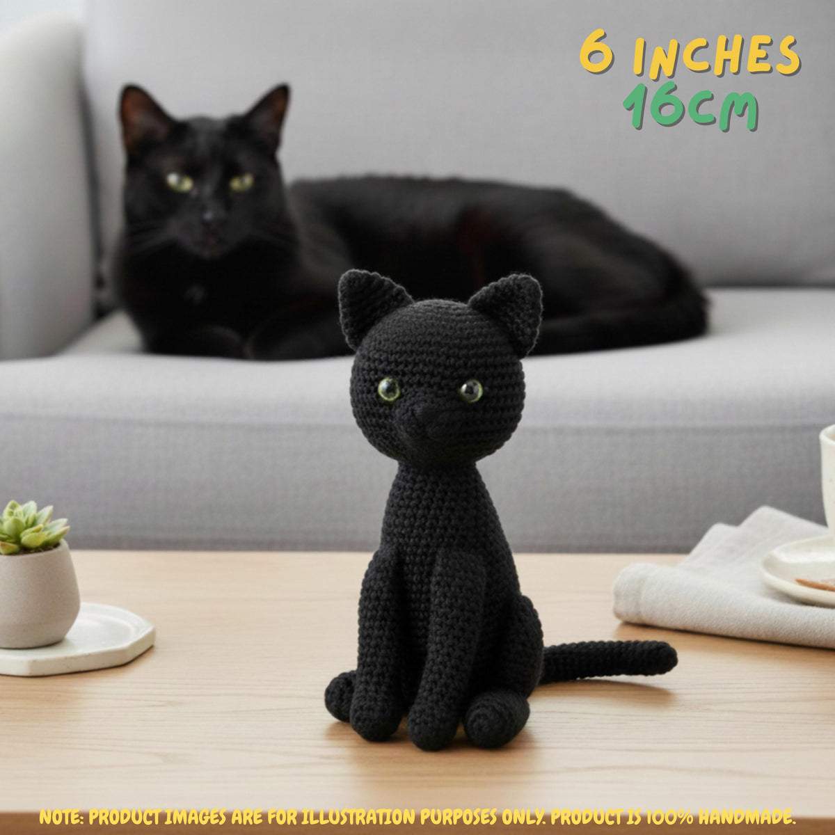 A black crocheted amigurumi cat sits on a wooden table in the foreground, with a real black cat resting on a light gray sofa in the background. Text in the top right reads '6 INCHES 16CM', and a note at the bottom says the product images are for illustration purposes only.