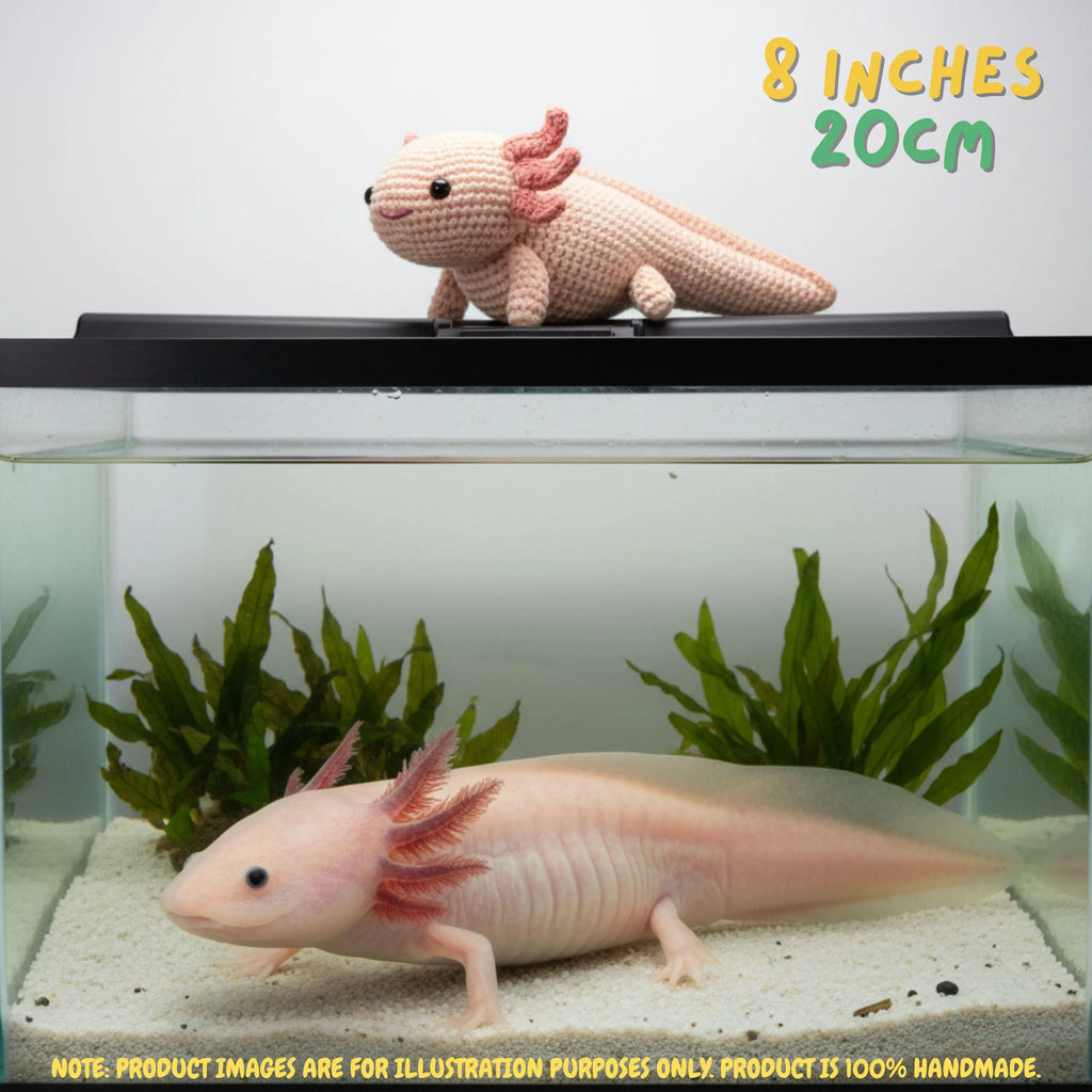 A crocheted axolotl toy sits on a black lid of an aquarium above a real axolotl swimming in a tank with green plants and white sand. Text reads '8 INCHES 20CM' and a note says product images are for illustration purposes only because the product is 100% handmade.