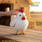 A crocheted white chicken toy with a red comb and wattle stands on a wooden table outdoors at sunset, with a human hand touching its head. Text in the top right says '8 INCHES 20CM' and a note at the bottom says product images are for illustration purposes only.