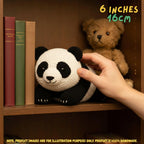 Hand being held next to a handmade giant panda bear crochet amigurumi plush doll sitting on a wooden bookshelf next to books and a brown teddy bear, with text reading 6 INCHES 16cm.
