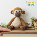 Crocheted plush monkey toy with brown and beige colors, sitting on a wooden shelf with small decorative plants and text indicating 6 inches / 16 cm size.