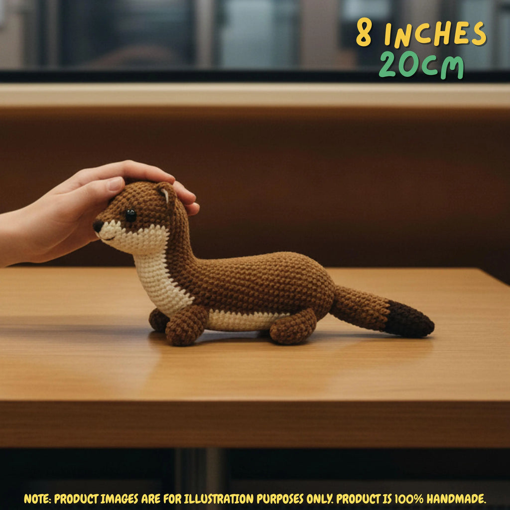 Handmade Stoat crochet amigurumi plush doll in brown and cream with a dark-tipped tail resting on a wooden table, with a hand gently touching its head and text indicating 8 inches 20 cm size.