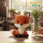 Handmade fox crochet amigurumi plush doll in orange, white, and dark brown sitting on a wooden table beside a glass flower vase.