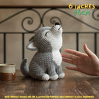 Handmade grey and white crochet wolf amigurumi doll in a howling posture sitting on a wooden table near a coffee mug, featuring "6 INCHES / 16CM" text overlay.
