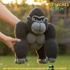 A crocheted gorilla toy being held by two hands outdoors, with text overlays indicating its size as 10 inches (25 cm) and a note that the product image is for illustration purposes only.