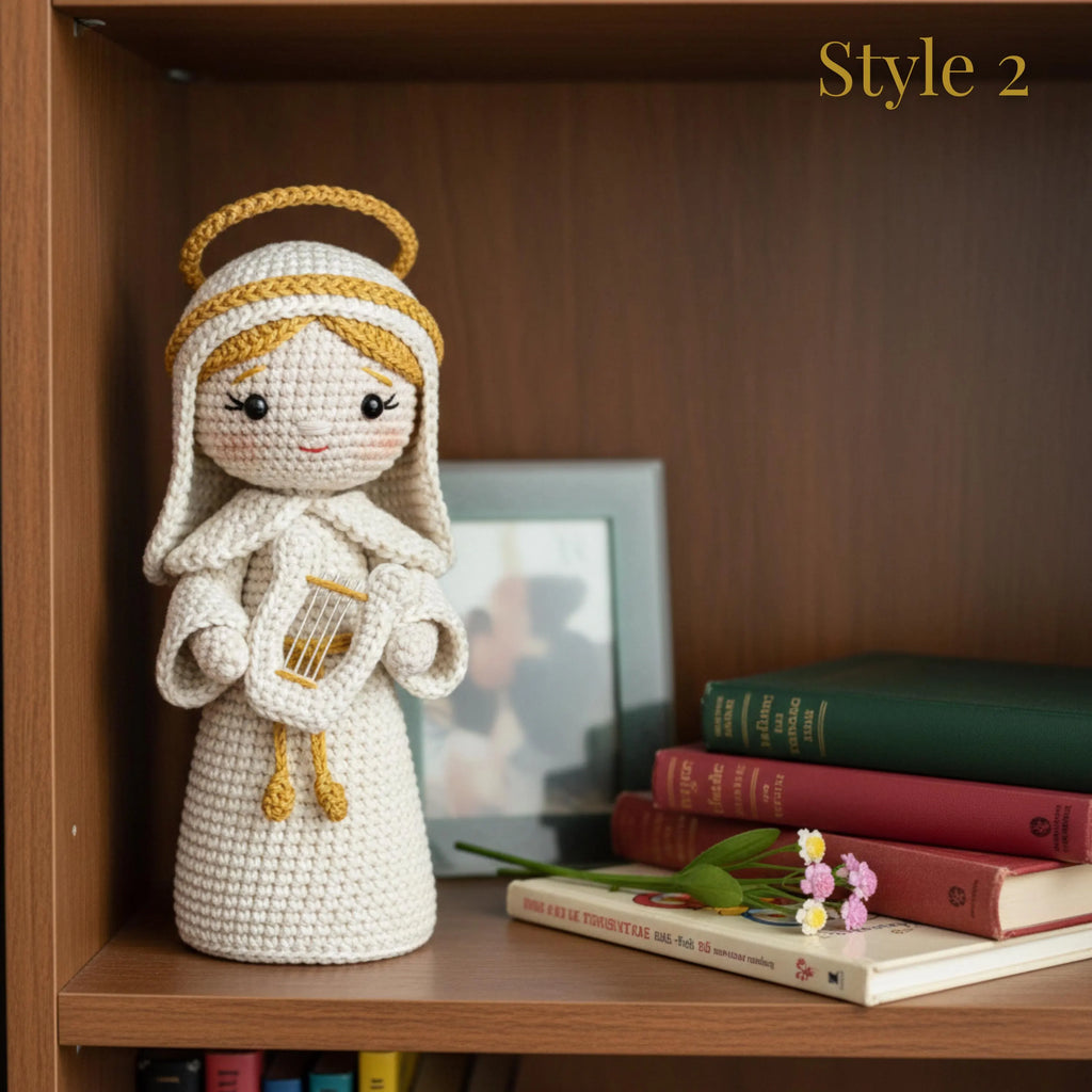 A crocheted angel doll with a gold halo and white dress stands on a wooden shelf next to books and small flowers. The text 'Style 2' appears in the top right corner.
