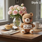 A crocheted teddy bear sits on a wooden table holding a sign that reads 'YOU ARE MY HOME.' The scene is styled like a breakfast table with pancakes, blueberries, a vase of pink roses, a white mug with steam, and the text 'Style 1' in the top right corner.