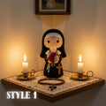 A crocheted nun figurine stands on a wooden shelf with two lit candles, a rosary, and a lace runner. The scene is warmly lit, and the text 'STYLE 1' appears in the lower left corner.