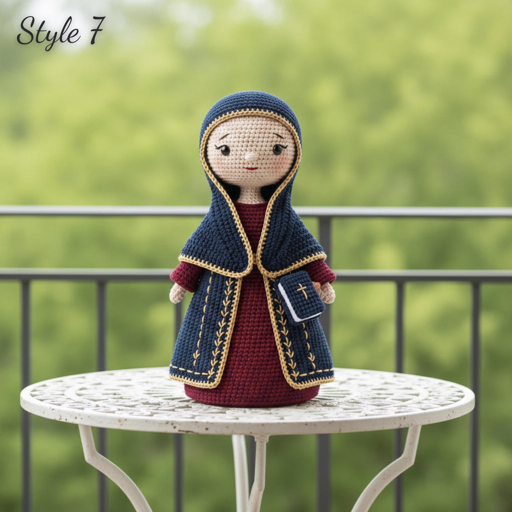A crocheted doll dressed in a dark blue hooded cloak with gold trim over a burgundy dress, standing on a white outdoor table with a blurred green garden background. The text 'Style 7' appears in the top left corner.