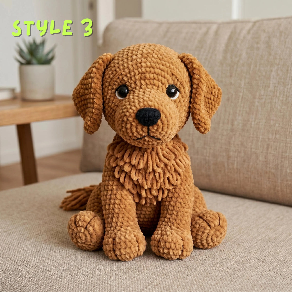 A brown textured plush dog toy with floppy ears, large black eyes, and a black nose, sitting on a beige sofa in a living room setting. The text 'STYLE 3' is written in green in the upper left corner.